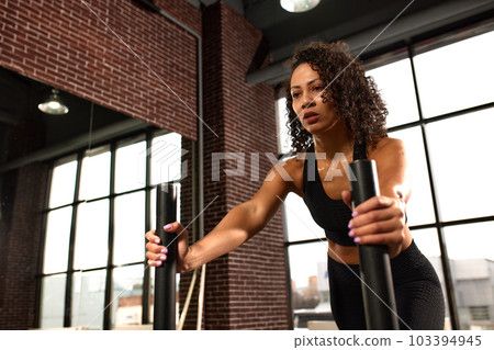 African American woman, crossfit, gym workout, longing and pushing weights, development of strength and endurance. African American woman, crossfit, gym workout, longing and pushing weights, development of strength and endurance. 103394945