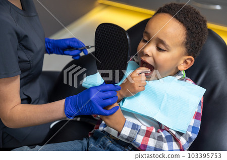 Doctor giving mirror to dark-skinned boy 103395753