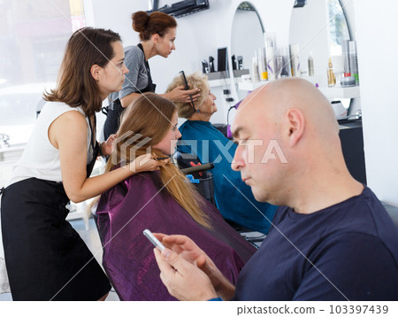 Teenage girl with father in hair salon Teenage girl with father in hair salon 103397439