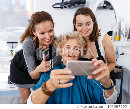 Hairstylists and female customer taking selfie Hairstylists and female customer taking selfie 103397505