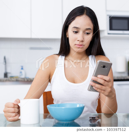 Girl with cup and smartphone Girl with cup and smartphone 103397512