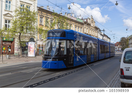 [Poland] A modern blue tram running through the historic streets of Krakow's Old Town 103398939