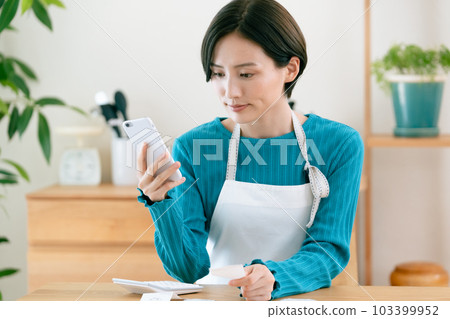 A woman who manages a household budget 103399952