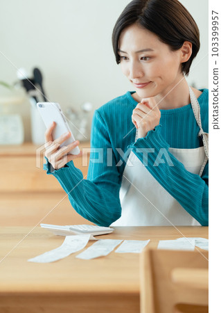 A woman who manages a household budget 103399957