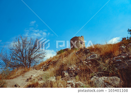 an ancient stone tower on a blue sky background an ancient stone tower on a blue sky background 103401108