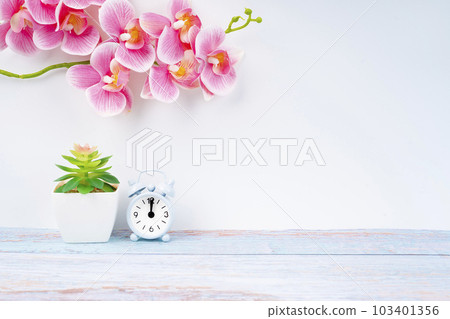The Alarm clock and pink color orchid on wooden floor with copy space for your design. 103401356