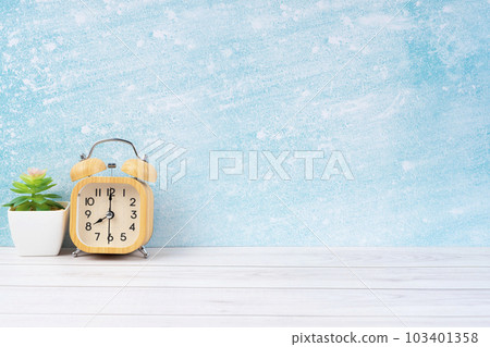 The Wooden alarm clock and plant pot on blue wooden floor with copy space for your design. 103401358