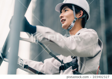 Young craftsmen working at heights in building construction Young craftsmen working at heights in building construction 103402327