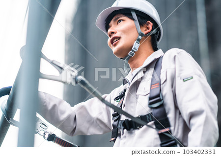 Young craftsmen working at heights in building construction Young craftsmen working at heights in building construction 103402331