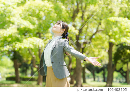 Photo of a woman taking a deep breath in the fresh green Photo of a woman taking a deep breath in the fresh green 103402505