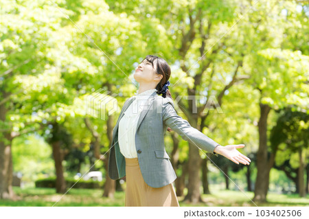 Photo of a woman taking a deep breath in the fresh green Photo of a woman taking a deep breath in the fresh green 103402506
