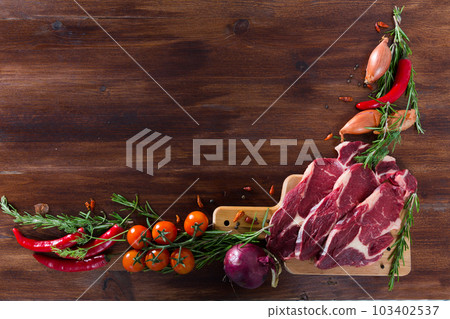 Fresh slices of beef and vegetables assortment on natural wooden desk Fresh slices of beef and vegetables assortment on natural wooden desk 103402537