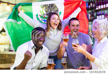 Happy fans celebrating the victory of Mexican team in bar 103402639
