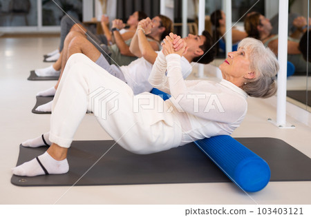 Elderly woman doing pilates with roller Elderly woman doing pilates with roller 103403121