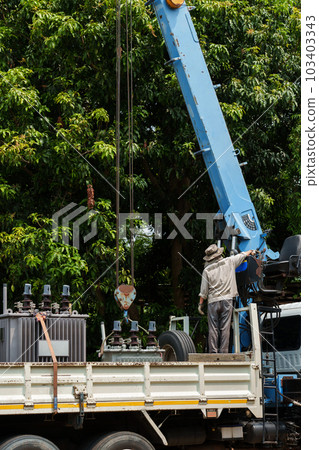 Crane hook lifts up distribution transformer 103403343