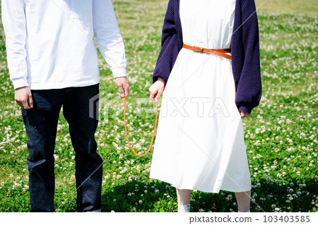 Couple with red string in the park 103403585