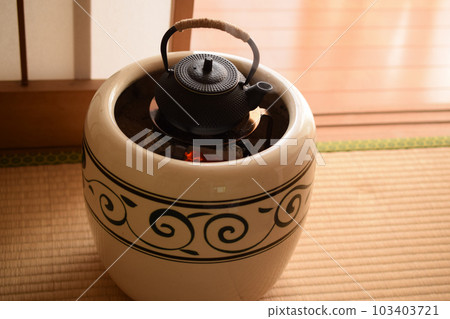 帶有熱氣騰騰的南部鐵器茶壺的火盆 103403721