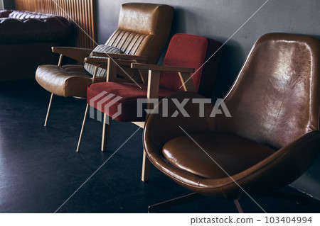 Interior with three armchairs on the background of an empty gray wall. Two chairs of different shapes and colors, with space for copying.Modern minimalist design. High quality photo Interior with three armchairs on the background of an empty gray wall. Two chairs of different shapes and colors, with space for copying.Modern minimalist design. High quality photo 103404994