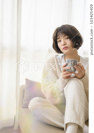 在沙發上放鬆的年輕女子（帶濾鏡） 103405409