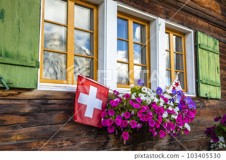 Flowers in rustic balcony at springtime with Swiss flag, Interlaken, Switzerland Flowers in rustic balcony at springtime with Swiss flag, Interlaken, Switzerland 103405530