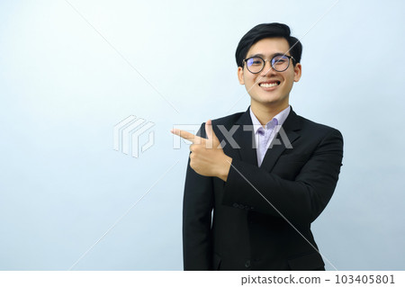 Portrait of businessman pointing and looking at camera. 103405801