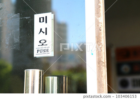 A glass door with a plate that says 'Please push' (Korea) A glass door with a plate that says 'Please push' (Korea) 103406153