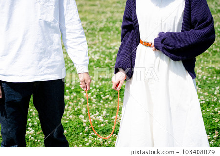 Couple with red string in the park Couple with red string in the park 103408079