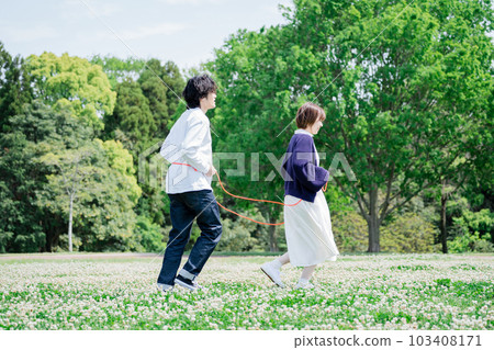 A couple playing train in a flower garden 103408171
