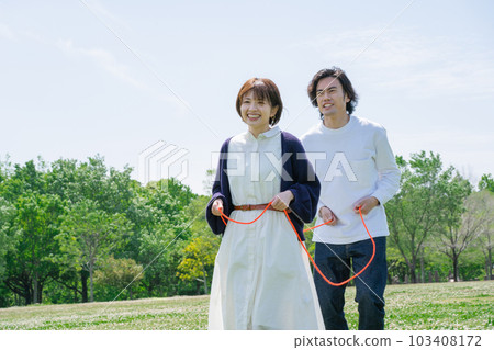 A couple playing train in a flower garden 103408172