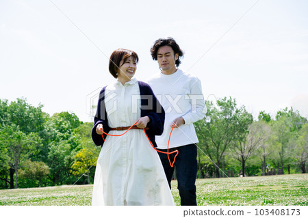 A couple playing train in a flower garden 103408173