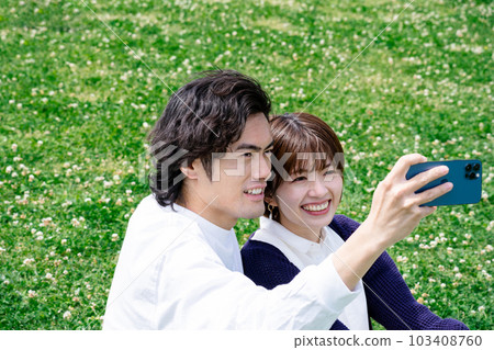 A couple taking a selfie in the green A couple taking a selfie in the green 103408760