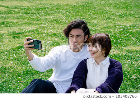 A couple taking a selfie in the green A couple taking a selfie in the green 103408766