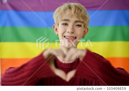 An attractive Asian queer or gay man showed the heart hand sign 103409859