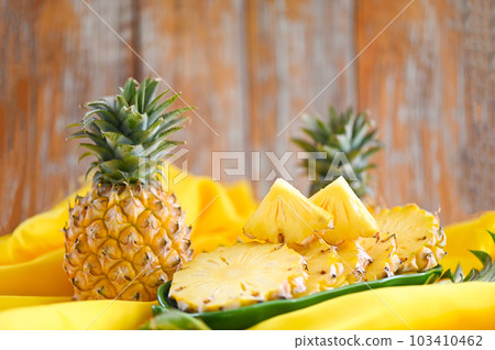 fresh pineapple tropical fruits summer, pineapple slice on plate for food fruit ripe pineapple on wooden background 103410462
