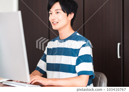 一個年輕人用電腦提交作業 一個年輕人用電腦提交作業 103410767