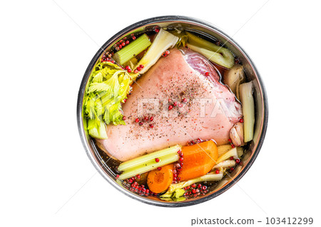 Cooking of Eisbein from Raw pork Hock ham, shank with vegetables and herbs. Isolated on white background. Cooking of Eisbein from Raw pork Hock ham, shank with vegetables and herbs. Isolated on white background. 103412299