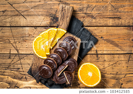 Chocolate Jaffa Cakes with Orange Flavored Marmalade. Wooden background. Top view Chocolate Jaffa Cakes with Orange Flavored Marmalade. Wooden background. Top view 103412585