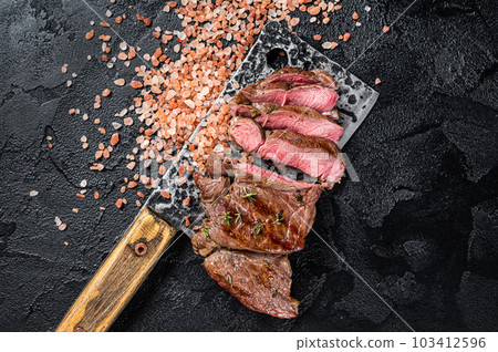 Sliced grilled Lamb fillet steak, mutton meat from leg. Black background. Top view 103412596