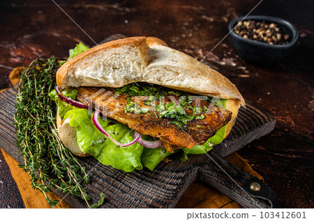 Turkish Street Food Balik Ekmek, fish sandwich with grilled mackerel fillet in a bun. Dark background. Top view 103412601