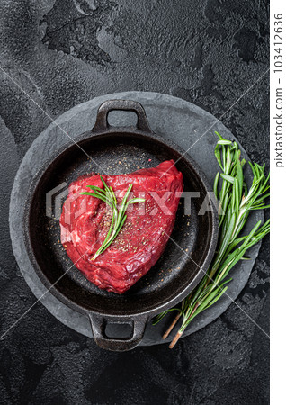 Fresh Raw sirloin rump steak in a skillet with herbs. Black background. Top view 103412636