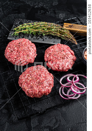 Raw minced beef cutlets with spices and herbs ready for cooking. Black background. Top view 103412638
