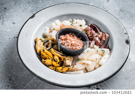 Raw seafood mix in a rustic plate. Gray background. Top view Raw seafood mix in a rustic plate. Gray background. Top view 103412681
