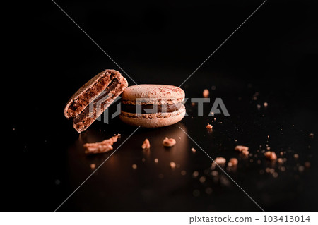 Array of Chocolate Macaroons Halved on Dark Background Array of Chocolate Macaroons Halved on Dark Background 103413014