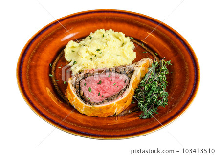 Beef Wellington pastry with mushed potato on a rustic plate. Isolated on white background. Beef Wellington pastry with mushed potato on a rustic plate. Isolated on white background. 103413510