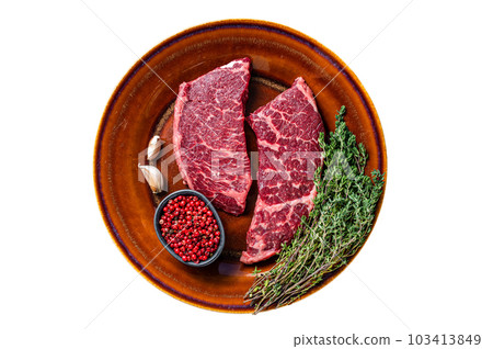 Fresh Raw denver or top blade meat steak on a rustic plate with thyme. Isolated on white background. 103413849