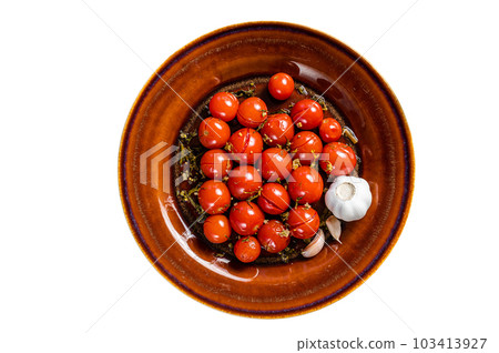 Marinated Preserve cherry tomatoes in a rustic plate with garlic and thyme. Isolated on white background. Marinated Preserve cherry tomatoes in a rustic plate with garlic and thyme. Isolated on white background. 103413927