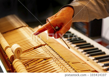 Delicate piano tuning by a mature technician 103414107