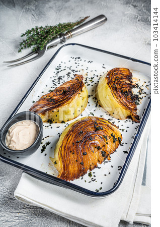 Healthy vegan Roasted cabbage steaks with spices in baking dish. White background. Top view Healthy vegan Roasted cabbage steaks with spices in baking dish. White background. Top view 103414144