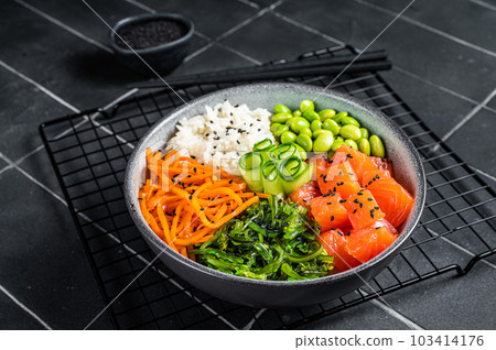 Hawaiian Poke bowl with Salmon, Edamame and Rice. Black background. Top view Hawaiian Poke bowl with Salmon, Edamame and Rice. Black background. Top view 103414176
