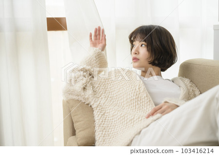 透過窗簾縫隙往外看的年輕女人 透過窗簾縫隙往外看的年輕女人 103416214